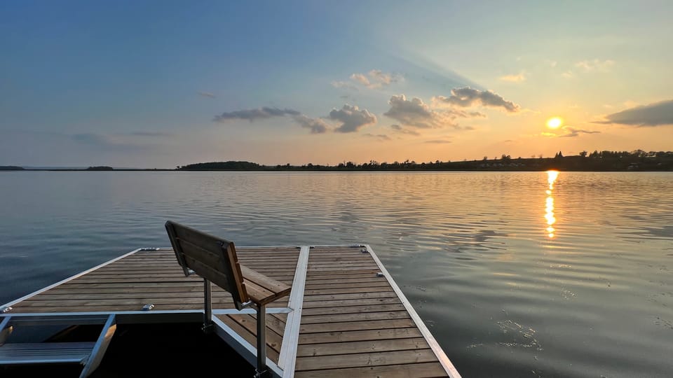 The bench at the end of the dock, facing the setting sun