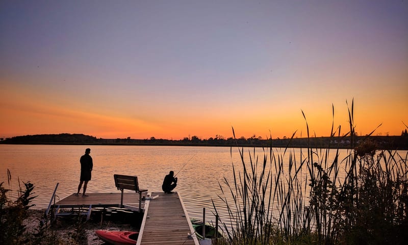 Two anglers on the dock at dusk